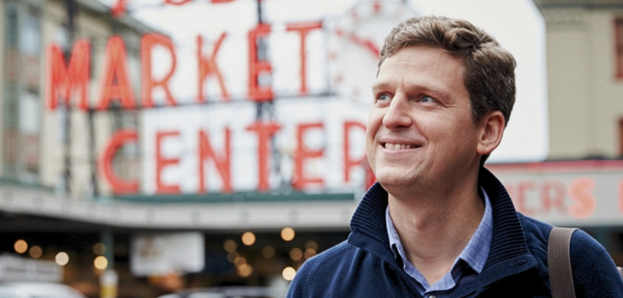 Portrait of James Ethnes in front of red neon Market sign