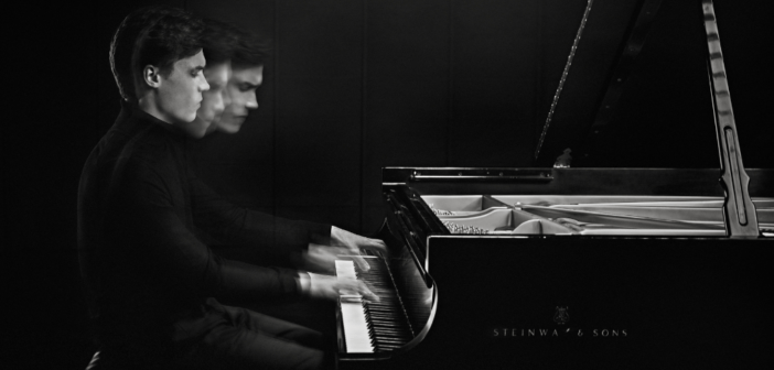Black and white image of Jaeden Izik-Dzurko playing the piano