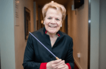 Headshot of conductor Marin Alsop holding a purple baton.