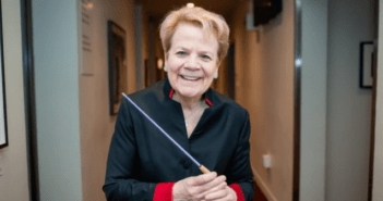 Headshot of conductor Marin Alsop holding a purple baton.