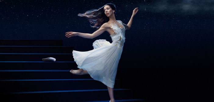 Une ballerine en robe blanche qui danse sur scène sous un ciel étoilé, créant une atmosphère onirique digne d'un conte de fées.